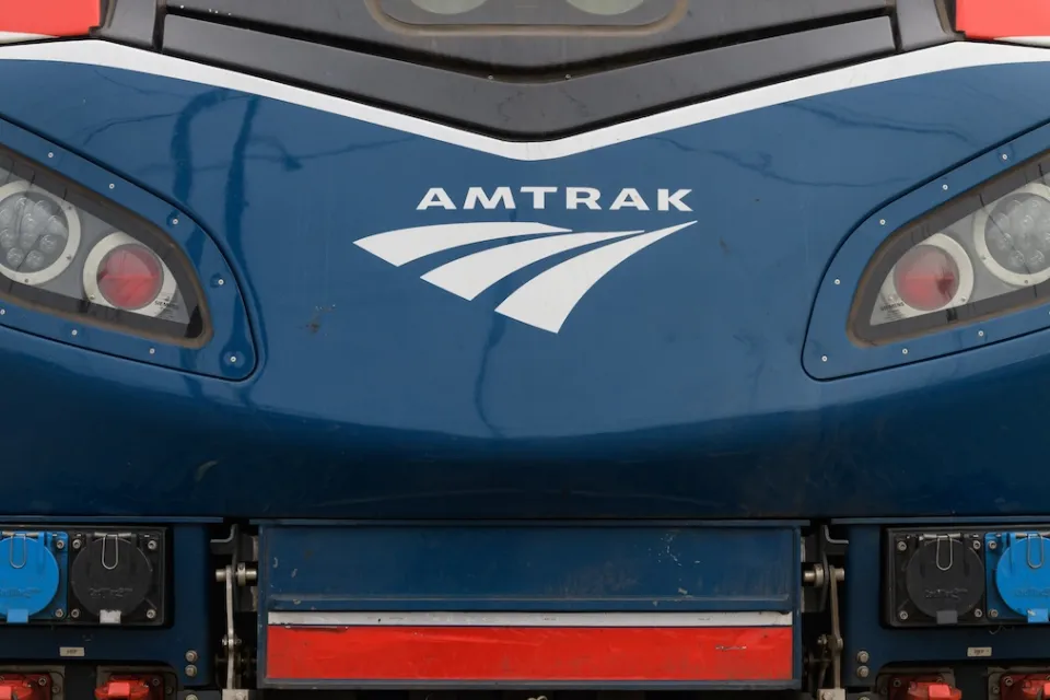 Close-up of front of blue locomotive with Amtrak logo.